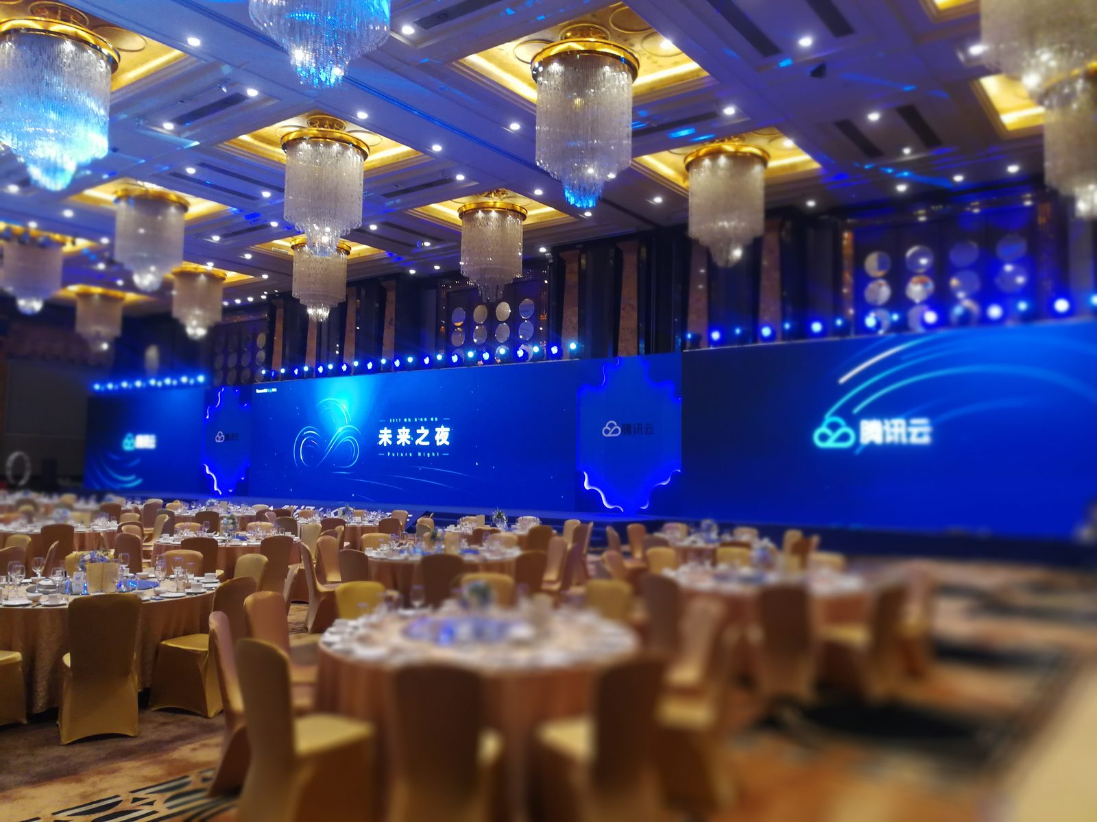 腾讯云金融科技之夜活动现场：蓝色主题舞台大屏与水晶吊灯宴会厅