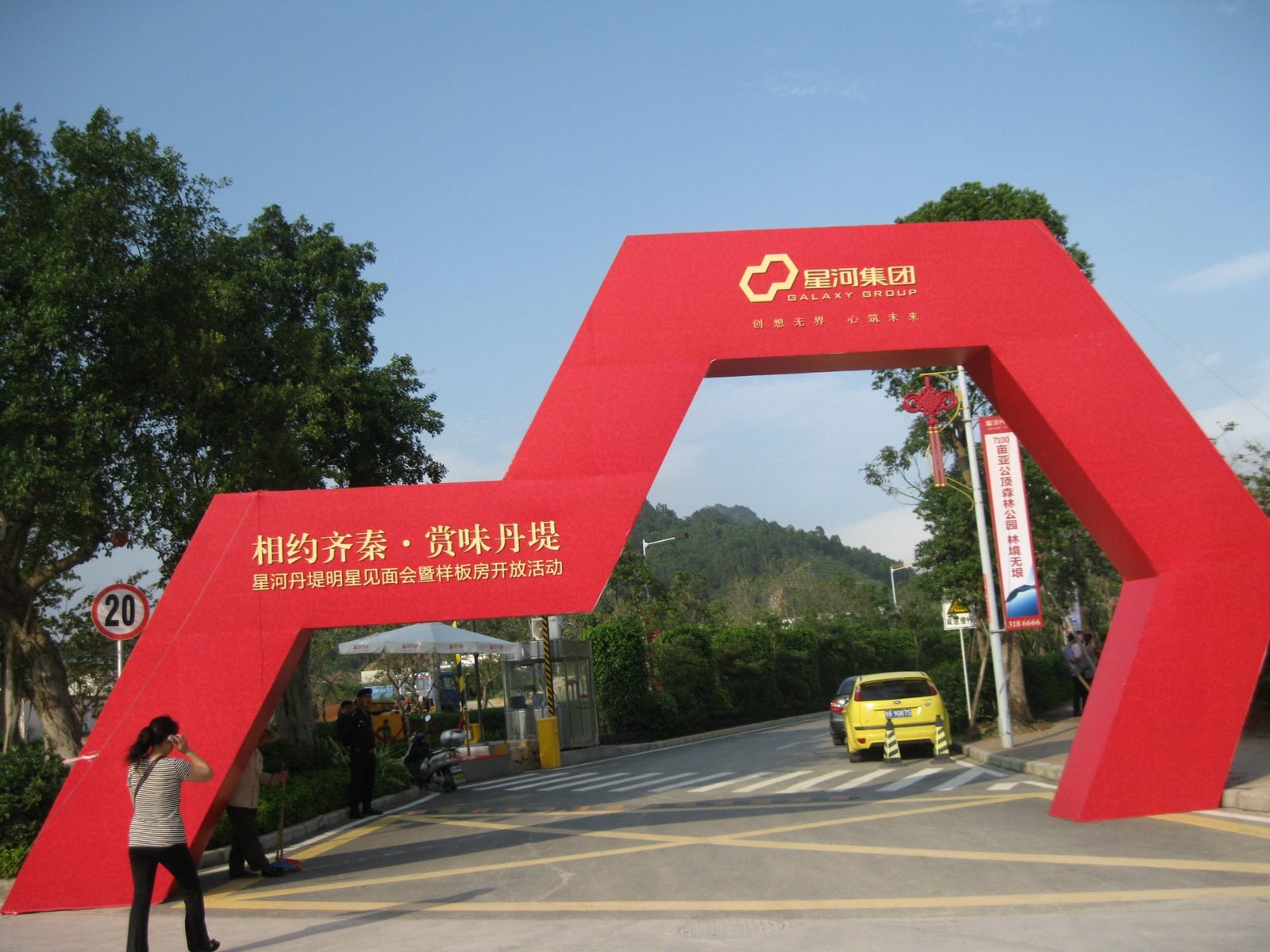 星河集团楼盘发布会现场入口：大型红色弧形门头「相约齐秦 赏味丹堤」迎宾装置